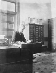 Woodbridge Ferris working at desk in office.